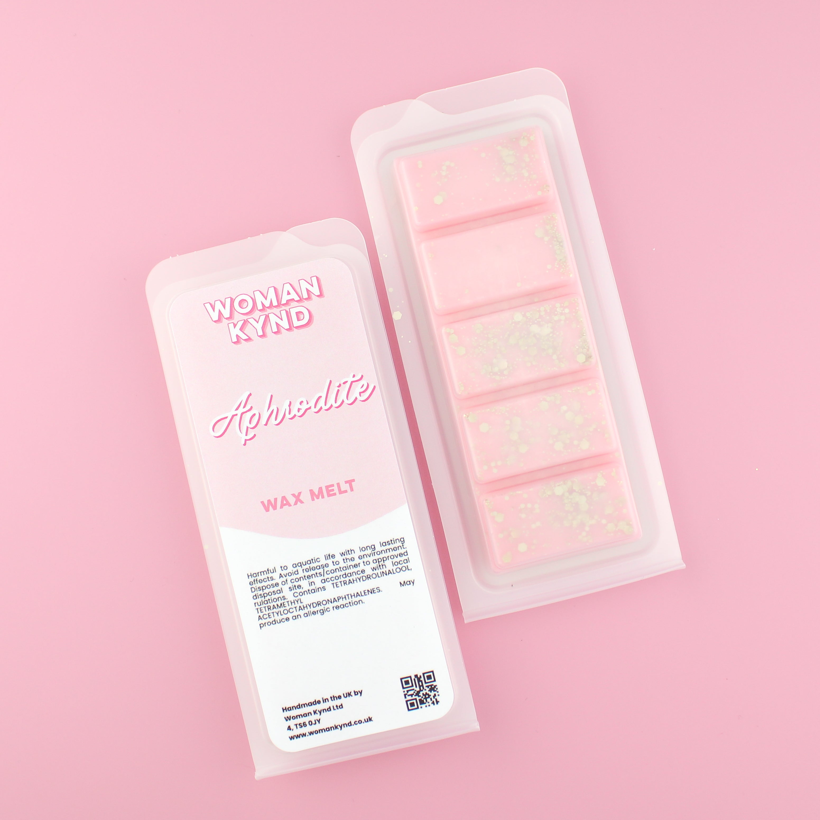 Two images of a Woman Kynd five segment pink Wax Melt with gold glitter, both in a frosted clamshell. The first image displays the pink and white label with the words Woman Kynd Aphrodite Wax Melt and the CLP information, and the other image is of the reverse side showing the Wax Melt Itself. Both images are against a solid pink background.
