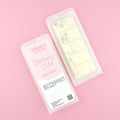 Two images of a Woman Kynd five segment cream coloured Wax Melt with multicoloured glitter, both in a frosted clamshell. The first image displays the pink and white label with the words Woman Kynd Birthday Cake Wax Melt and the CLP information, and the other image is of the reverse side showing the Wax Melt Itself. Both images are against a solid pink background.