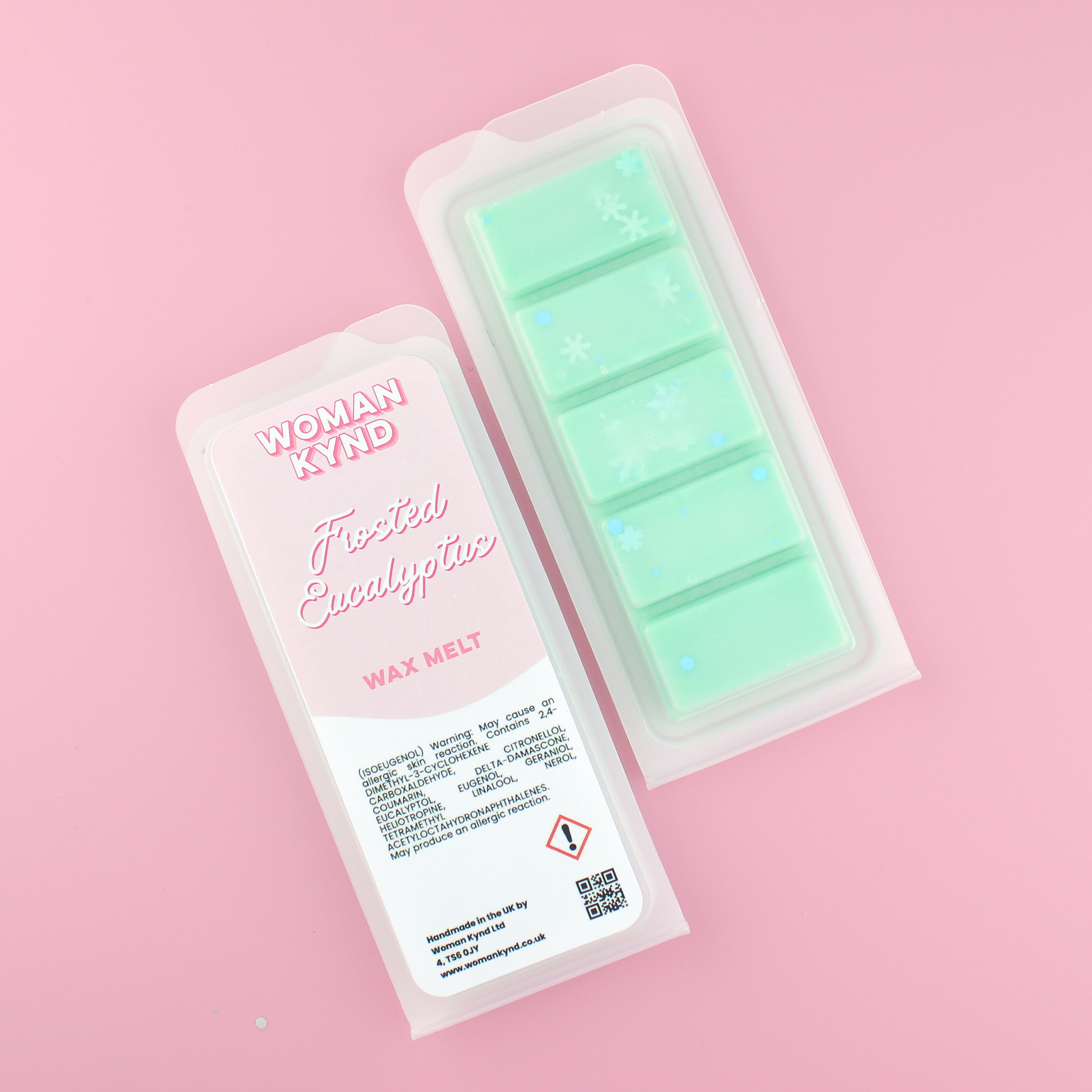 Two images of a Woman Kynd five segment mint green Wax Melt with white, snowflake shaped glitter, both in a frosted clamshell. The first image displays the pink and white label with the words Woman Kynd Frosted Eucalyptus Wax Melt and the CLP information, and the other image is of the reverse side showing the Wax Melt Itself. Both images are against a solid pink background.