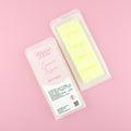 Two images of a Woman Kynd five segment pale yellow Wax Melt with white glitter, both in a frosted clamshell. The first image displays the pink and white label with the words Woman Kynd Lemon Sugar Wax Melt and the CLP information, and the other image is of the reverse side showing the Wax Melt Itself. Both images are against a solid pink background.