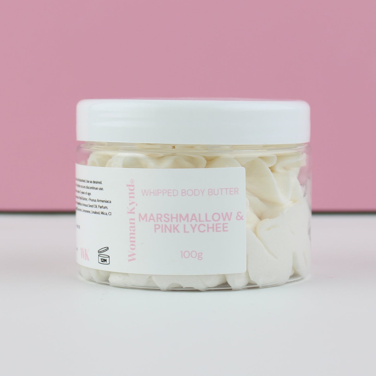 Jar of whipped body butter with a pink and white background