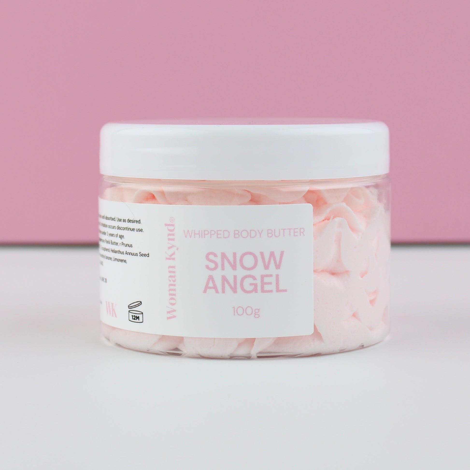 Jar of 'Snow Angel' whipped body butter with a pink and white label on a light pink background