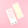 Two images of a Woman Kynd five segment cream coloured Wax Melt with light gold glitter, both in a frosted clamshell. The first image displays the pink and white label with the words Woman Kynd Sugar Cookie Wax Melt and the CLP information, and the other image is of the reverse side showing the Wax Melt Itself. Both images are against a solid pink background.