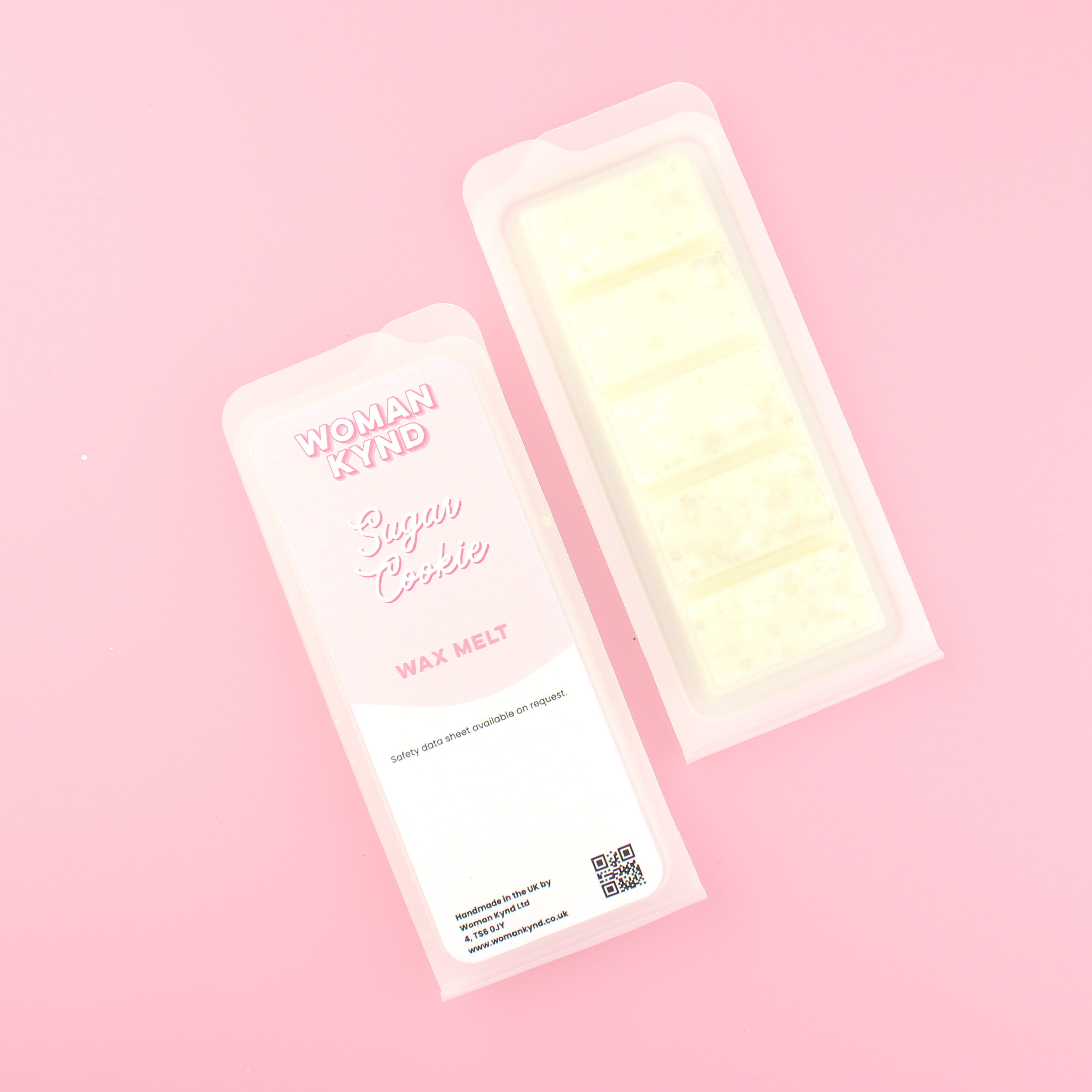Two images of a Woman Kynd five segment cream coloured Wax Melt with light gold glitter, both in a frosted clamshell. The first image displays the pink and white label with the words Woman Kynd Sugar Cookie Wax Melt and the CLP information, and the other image is of the reverse side showing the Wax Melt Itself. Both images are against a solid pink background.