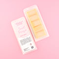 Two images of a Woman Kynd five segment fluorescent orange Wax Melt with orange glitter, both in a frosted clamshell. The first image displays the pink and white label with the words Woman Kynd Sweet Orange Wax Melt and the CLP information, and the other image is of the reverse side showing the Wax Melt Itself. Both images are against a solid pink background.
