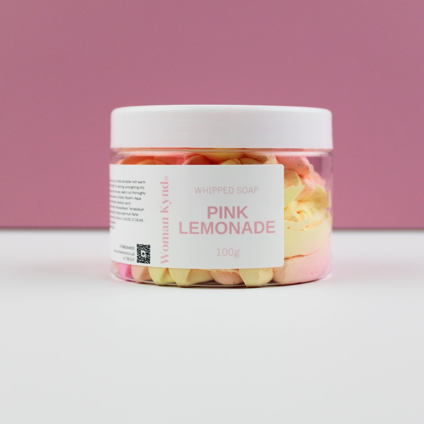 A clear jar filled with pink whipped soap, with a white lid and a label that reads 'PINK LEMONADE 100g'.
